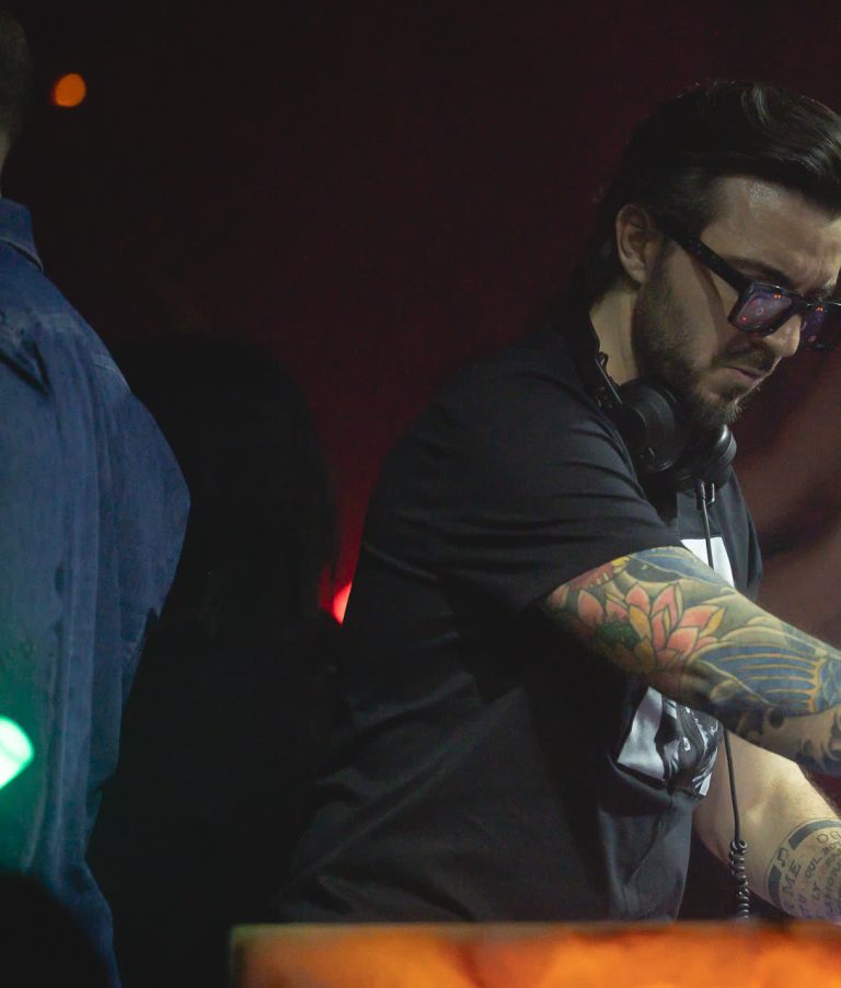 Il dj in consolle, il braccio teso sul pubblico