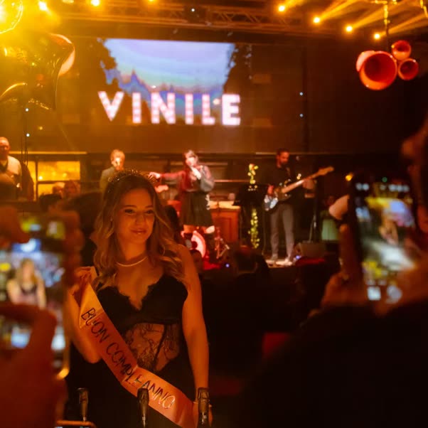 Una festa di compleanno con la fascia e la torta, la band che suona sul palco dietro